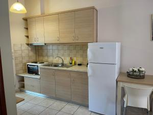 a kitchen with a white refrigerator and a sink at Karras Apartments in Gliki