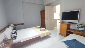 a bedroom with a bed and a flat screen tv at Little Hause in Psakoudia