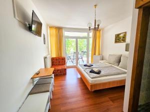 a bedroom with a bed and a living room at Weinberger Vendégház in Zamárdi