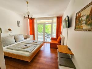 a bedroom with a bed and a couch and a table at Weinberger Vendégház in Zamárdi