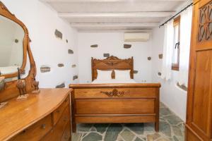 a bedroom with a wooden bed and a wooden dresser at Liostasi Tinos in Agios Fokas