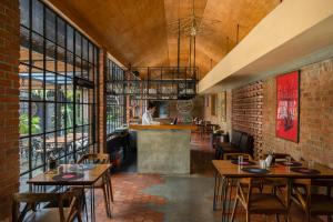 a restaurant with tables and a person in the kitchen at Hotel Aida in Kottayam