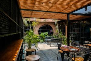 a patio with tables and chairs and a wooden pergola at Hotel Aida in Kottayam