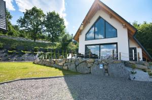 a home with a stone retaining wall and a house at Wejdz na Housine,pl Zator in Zator