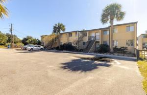 a parking lot in front of a building with palm trees at Sea Palm G in Fort Walton Beach