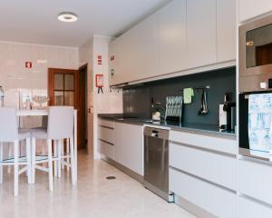a kitchen with a counter and a table in it at Lourença Stays - Vila Beach Apartment 1 in Vila do Conde