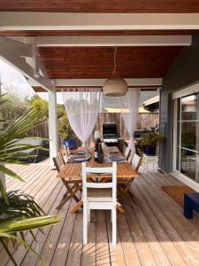 a wooden deck with a table and chairs on it at Entre bassin & océan in Lège-Cap-Ferret