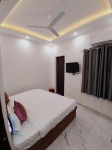 a bedroom with a bed and a flat screen tv at Hotel Pantao Rishekesh in Rishīkesh