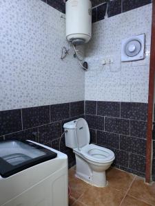 a bathroom with a toilet and a water tank at نزل مشترك هوستيل in Khamis Mushayt