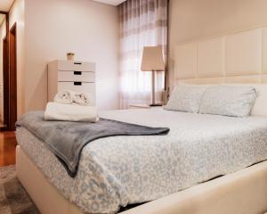 a bedroom with a large bed with a blue blanket at Lourença Stays - Vila Beach Apartment 1 in Vila do Conde