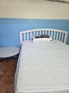 a white bed in a room with a blue wall at نزل مشترك هوستيل in Khamis Mushayt