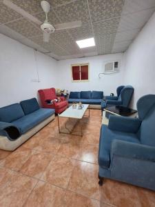 a waiting room with blue couches and a table at نزل مشترك هوستيل in Khamis Mushayt