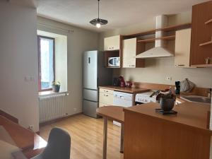 a kitchen with a white refrigerator and a table at Appartement - Baume-les-Dames in Baume-les-Dames +2 photos