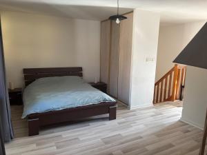 a bedroom with a bed and a wooden floor at Appartement - Baume-les-Dames in Baume-les-Dames