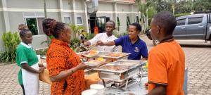 a group of people standing around a buffet of food at Kagera Breeze Resort in Mbarara