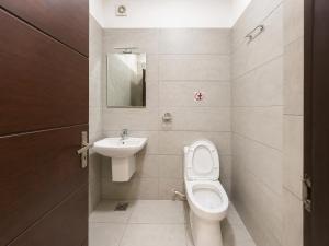 a small bathroom with a toilet and a sink at Raaha Residency in Kozhikode