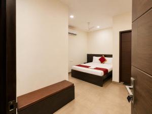 a bedroom with a bed with a red pillow at Raaha Residency in Kozhikode +24 photos