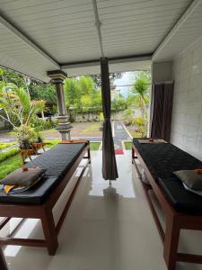 two beds in a room with a porch at Kawandini Homestay in Sidemen