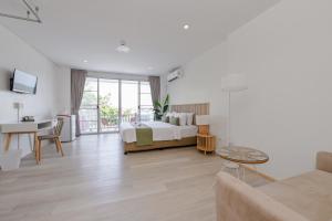 a bedroom with a bed and a desk and a couch at Little Home Ao Nang in Ao Nang Beach
