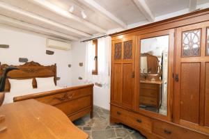 a bedroom with a bed and a wooden dresser at Liostasi Tinos in Agios Fokas +22 photos