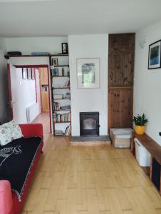 a living room with a red couch and a fireplace at New Ross Farm Cottage in New Ross