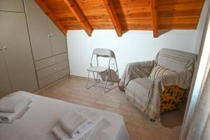 ein Zimmer mit einem Bett und einem Stuhl in der Unterkunft Araxos Loft in Áraxos