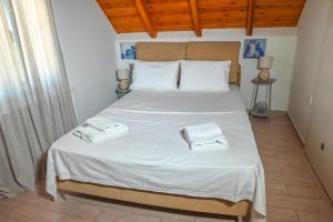 ein Schlafzimmer mit einem Bett, auf dem zwei Handtücher liegen in der Unterkunft Araxos Loft in Áraxos