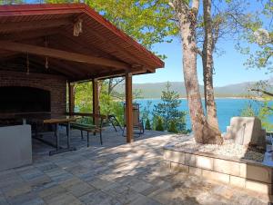 a patio with a fireplace and a table and a tree at Apartman Ramljak in Prozor +11 photos