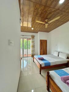 a bedroom with two beds and a swimming pool at Nandana Homestay in Udawalawe +28 photos