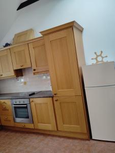 a kitchen with wooden cabinets and a white refrigerator at New Ross Farm Cottage in New Ross +6 photos