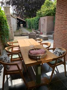 a wooden table with chairs and a basket on it at Luxe kamer centrum Sluis in Sluis