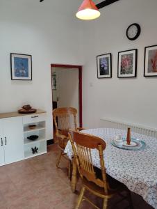a dining room with a table and chairs and a clock at New Ross Farm Cottage in New Ross
