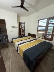 a bedroom with two beds and a ceiling fan at AC Room with attached bathroom and kitchen access in Zirakpur