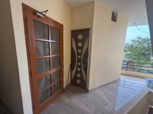 a room with a door and a balcony at AC Room with attached bathroom and kitchen access in Zirakpur
