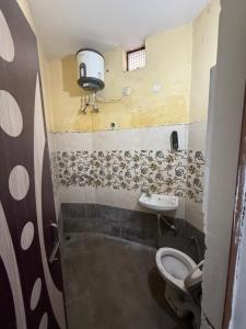 a bathroom with a toilet and a sink at AC Room with attached bathroom and kitchen access in Zirakpur