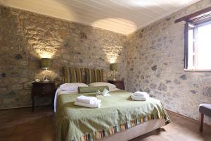 a bedroom with a bed with towels on it at Semantron Traditional Village in Diakopto