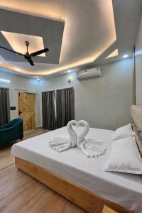 a bedroom with a bed with two towels on it at Ekantam Mountain Cottages in Dehradun