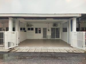 a garage with white doors and a wooden porch at Angah Homestay in Kampong Chabang