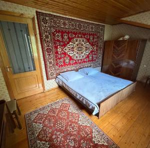 a bedroom with a bed and a wall with a rug at Guest House Raisa in Dilijan +12 photos