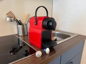 a red suitcase sitting on a counter next to a sink at Gemütliche Ferienwohnung nähe Schloss Benrath & Rhein Düsseldorf Urdenbach in Düsseldorf