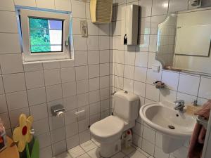 a white bathroom with a toilet and a sink at Gemütliche Ferienwohnung nähe Schloss Benrath & Rhein Düsseldorf Urdenbach in Düsseldorf