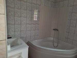 a white bathroom with a tub and a sink at Villa melys in Petite Île