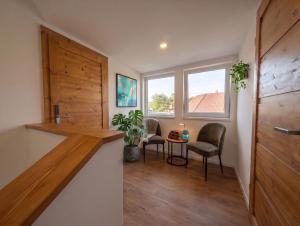 a room with two chairs and a table and a window at Templomdomb Apartmanház in Tapolca