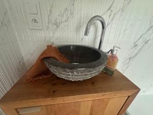a black sink with a faucet on top of a wooden table at Apartment Studio Aurora in Bad Schandau +17 photos