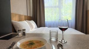 a table with a bowl of soup and a glass of wine at Axiom Suites - Nova 3 in KoÅ¡ickÃ© KÃºpele