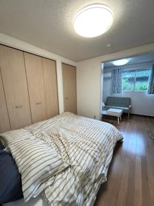 a bedroom with a bed with a striped comforter at Shalom House Yokosuka in Yokosuka