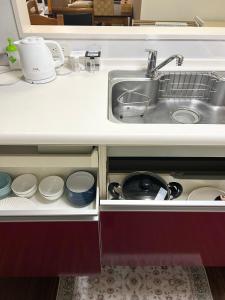 a kitchen counter with a sink and dishes at Shalom House Yokosuka in Yokosuka +14 photos