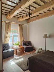 a bedroom with a bed and two chairs and a table at Viesu Nams Vilhelmīne in Līgatne