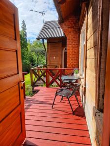 a wooden deck with a table and a bench on it at Viesu Nams Vilhelmīne in Līgatne +5 photos