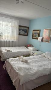 a bedroom with three beds and a window at Viksjo Centrum Apartment in Järfälla